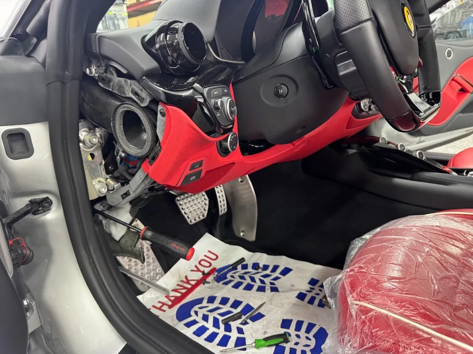 Under-dash panels removed on a Ferrari F12 for electronics work