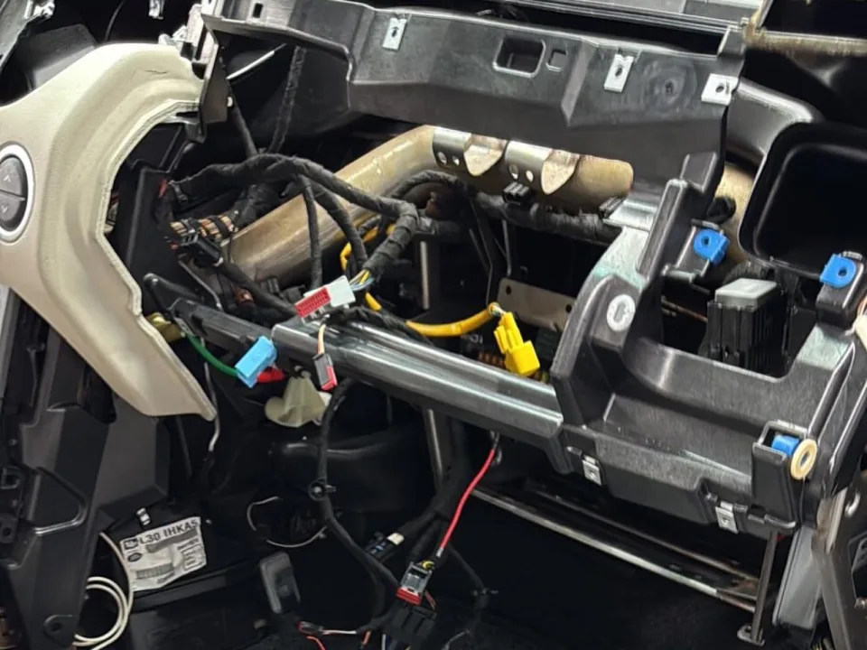 Wiring exposed under the dash during vehicle electronics work at Conexion
