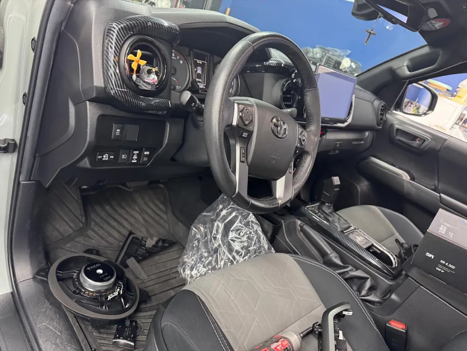 Speakers being swapped in a Toyota Tacoma with the door and dash trim off